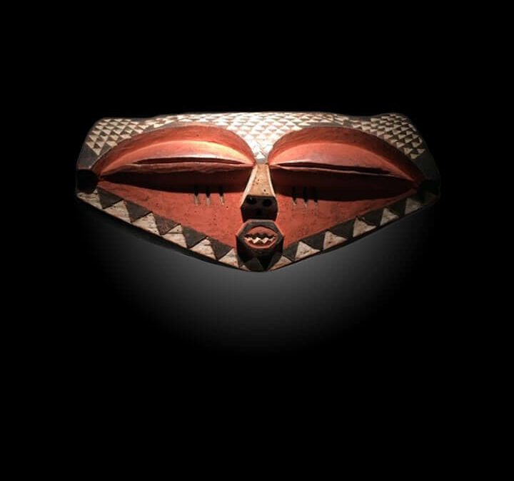 Elongated carved red and white tribal mask